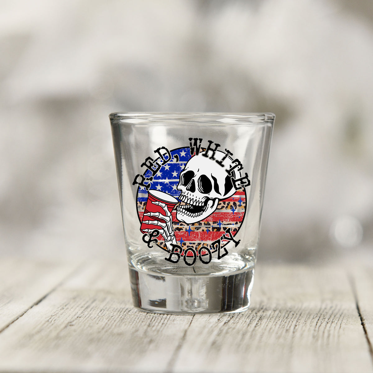 Close-up of the Red White and Boozy UV DTF transfer on a clear shot glass