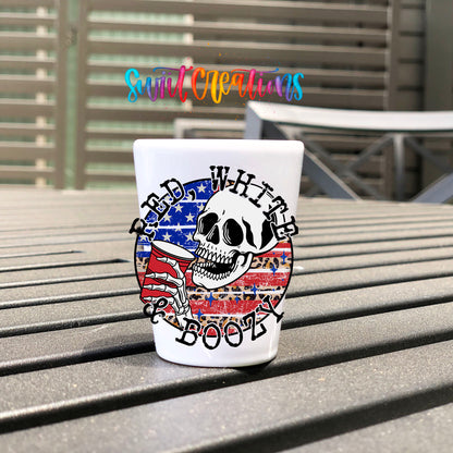 Red White and Boozy UV DTF transfer on a white shot glass on an outdoor patio table