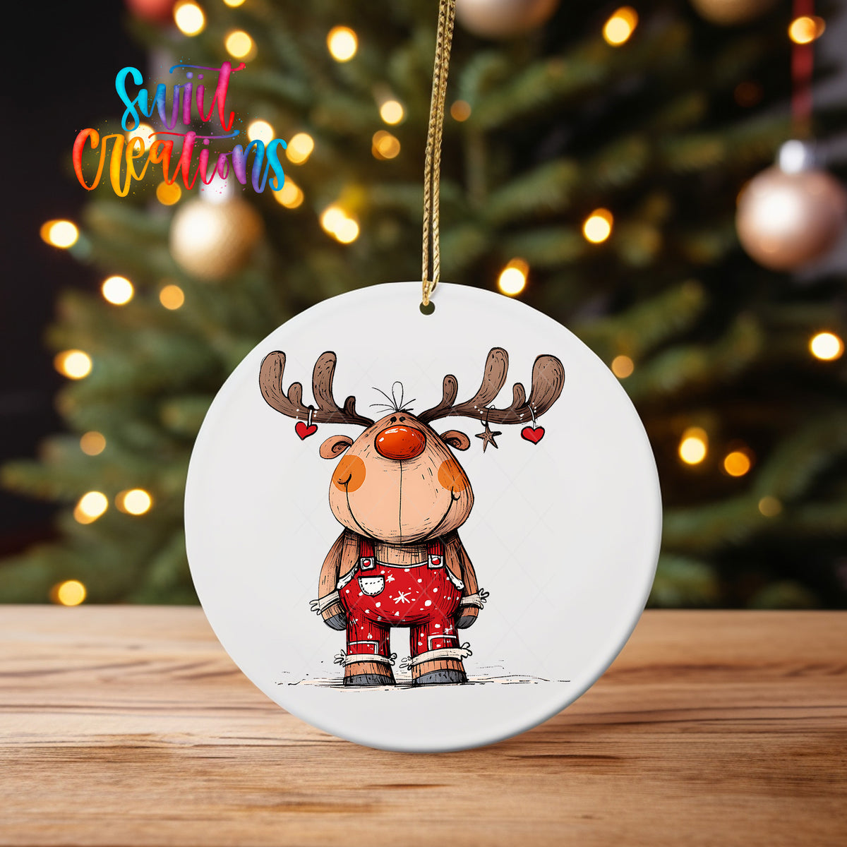 Reindeer with Hanging Hearts ornament UV DTF transfer on an ornament on a wooden table with tree lights behind it