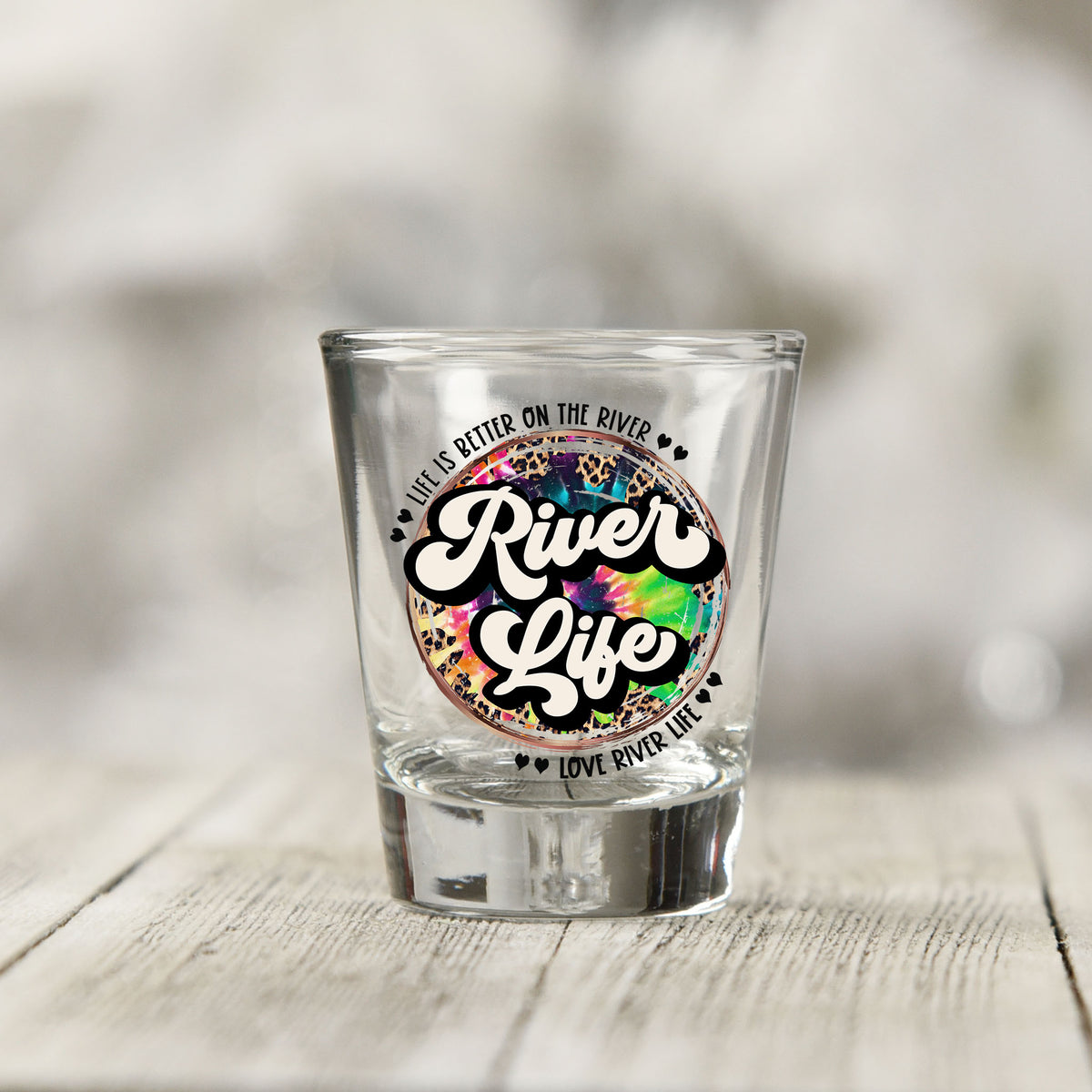 Close-up of the River Life UV DTF transfer on a clear shot glass