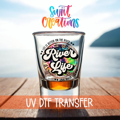 River Life shot glass UV DTF transfer on a filled shot glass on a dock by the water