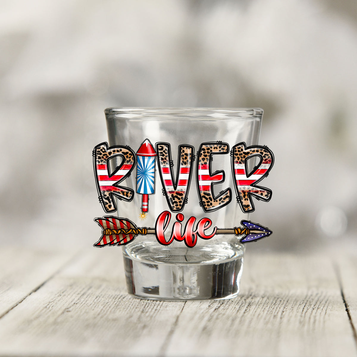 Close-up of the River Life USA UV DTF transfer on a clear shot glass