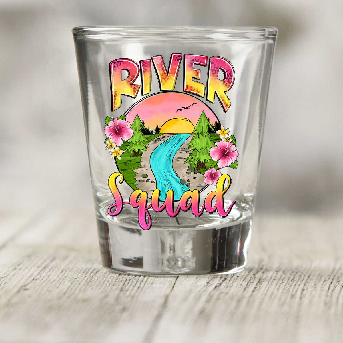 River Squad shot glass UV DTF transfer with sunset river scene with trees and flowers on a clear shot glass
