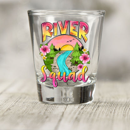 River Squad shot glass UV DTF transfer with sunset river scene with trees and flowers on a clear shot glass
