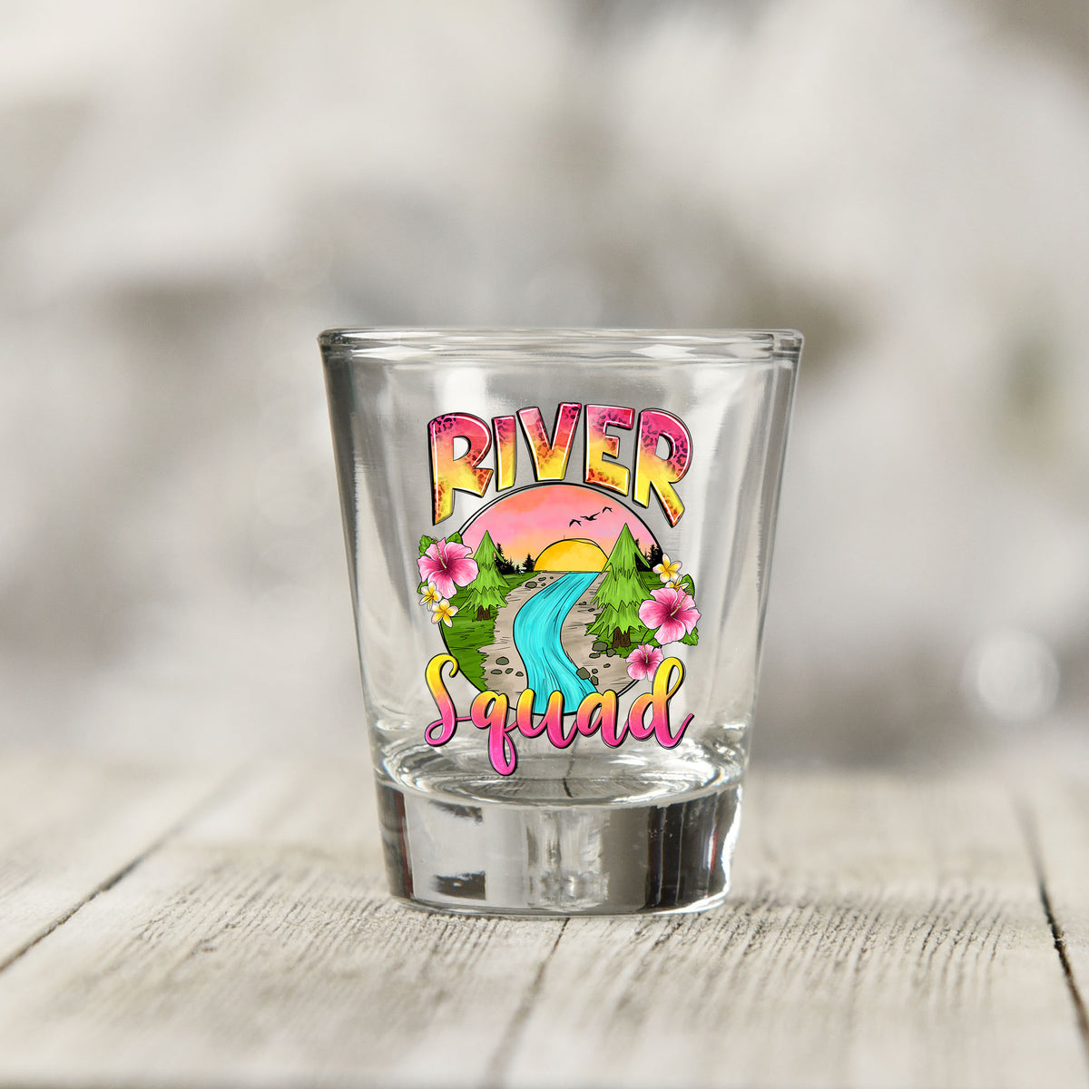 Close-up of the River Squad UV DTF transfer on a clear shot glass