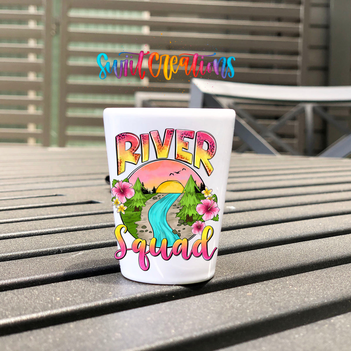 River Squad UV DTF transfer on a white shot glass on an outdoor patio table