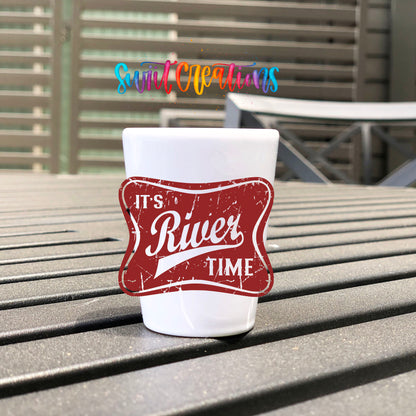 River Time UV DTF transfer on a white shot glass on an outdoor patio table
