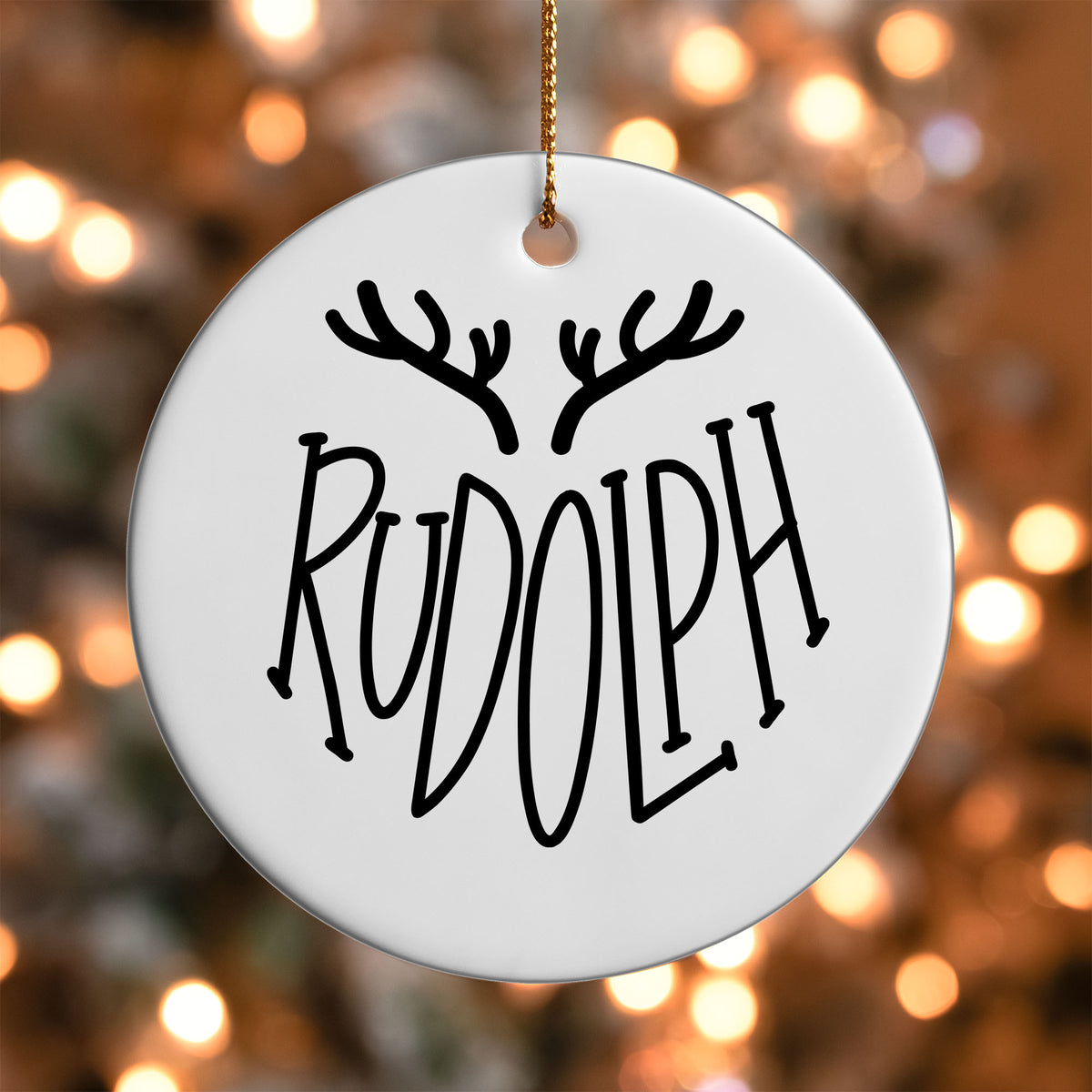 Rudolph Reindeer Name ornament UV DTF transfer on a round white ornament with a bokeh light background