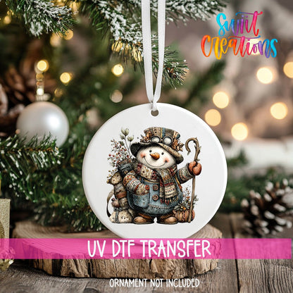 Rustic Vintage Snowman ornament UV DTF transfer on an ornament resting on a wood slice beside a Christmas tree
