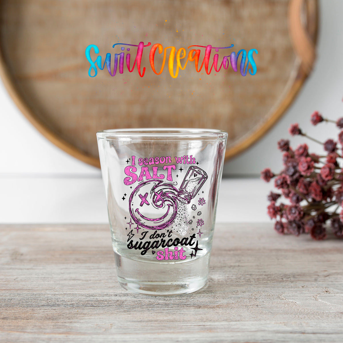 Salt Season Adult Humor shot glass transfer on a clear glass beside a wooden barrel and dried flowers