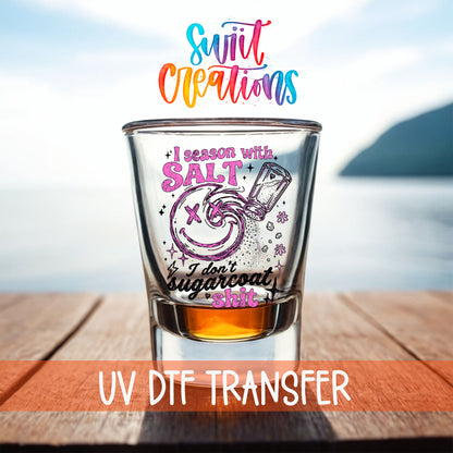Salt Season Adult Humor shot glass UV DTF transfer on a filled shot glass on a dock by the water