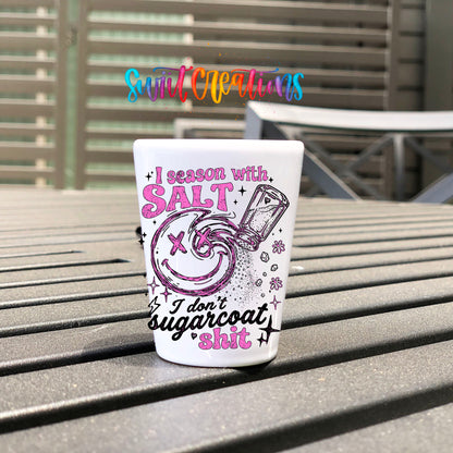 Salt Season Adult Humor UV DTF transfer on a white shot glass on an outdoor patio table