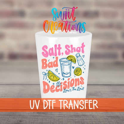 Salt Shot Bad Decisions UV DTF transfer on a white shot glass in front of a brick wall