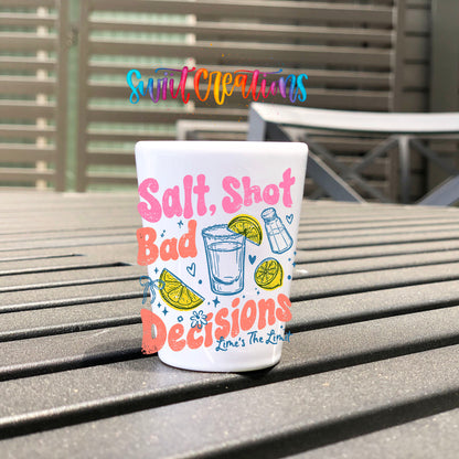 Salt Shot Bad Decisions UV DTF transfer on a white shot glass on an outdoor patio table