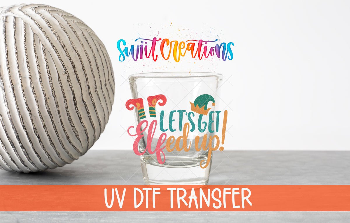 Let's Get Elfed Up Christmas elf shot glass UV DTF transfer shown on a clear shot glass beside a ribbed vase with an orange UV DTF Transfer banner.