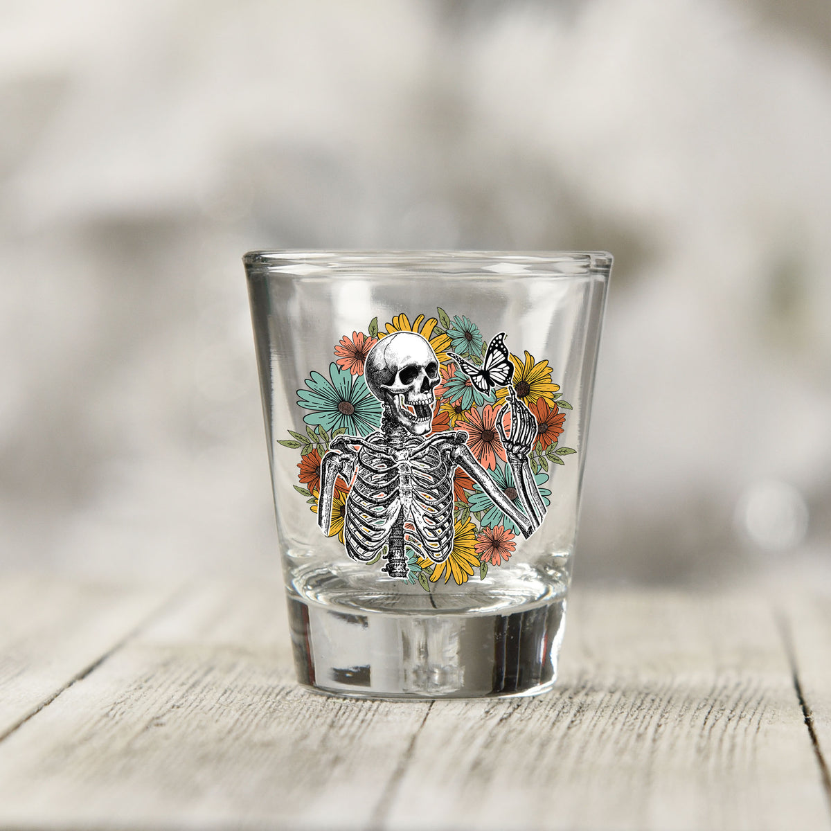Close-up of the Skeleton Floral UV DTF transfer on a clear shot glass