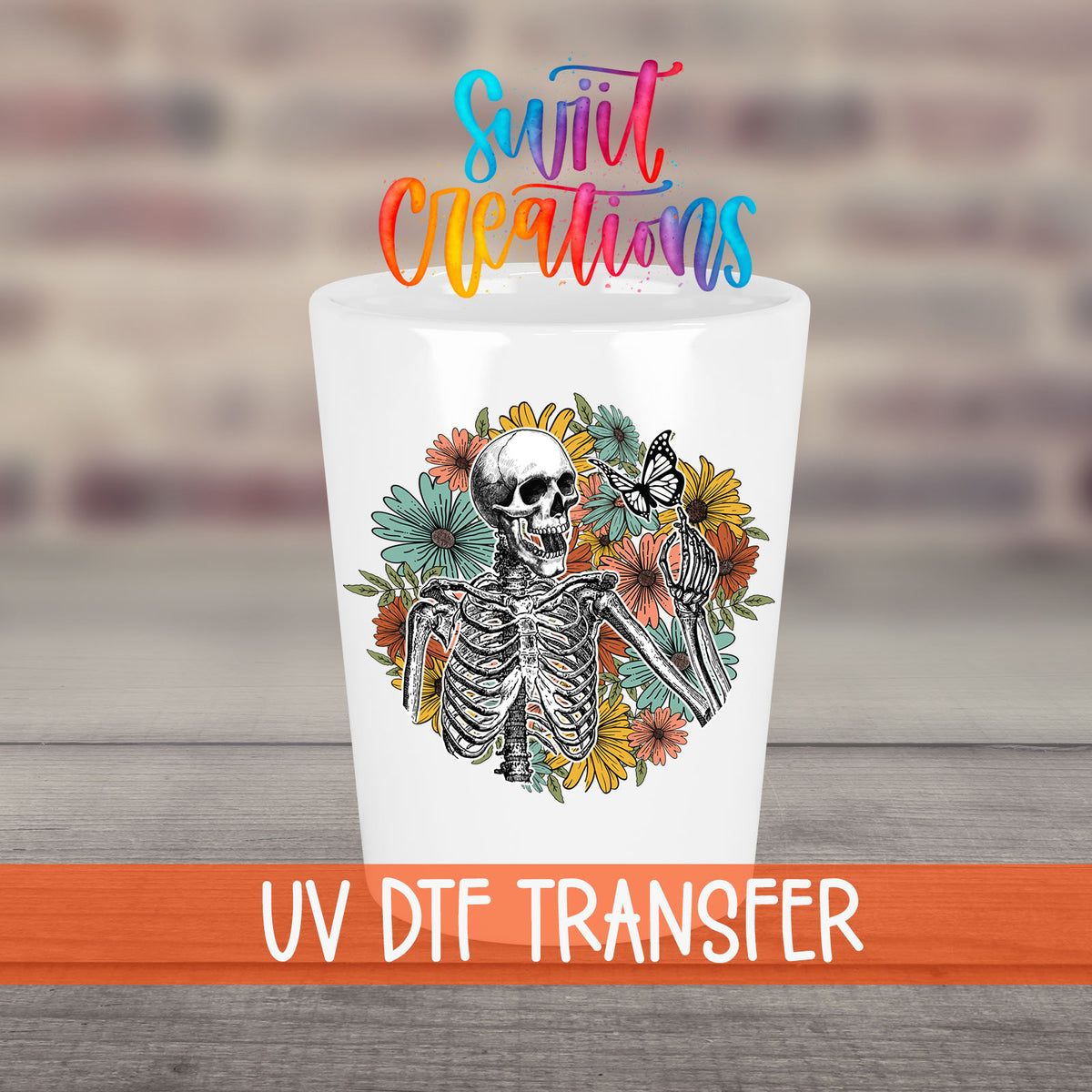 Skeleton Floral UV DTF transfer on a white shot glass in front of a brick wall
