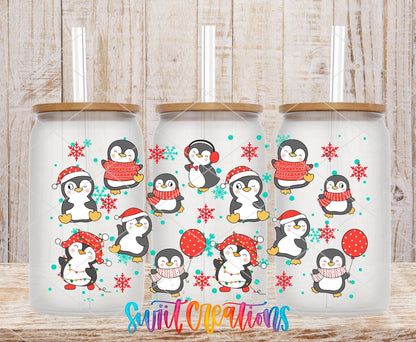 Christmas Penguins UV DTF wrap on three clear glass cans with bamboo lids