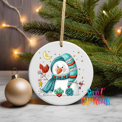 Snowman and Cardinal ornament UV DTF transfer on a hanging ornament with pine branches and a gold bauble