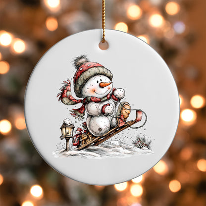 Snowman on a Sled ornament UV DTF transfer on a round white ornament with a bokeh light background