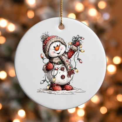 Snowman with Christmas Lights ornament UV DTF transfer on a round white ornament with a bokeh light background
