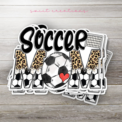 Stack of Soccer Mom glossy stickers on a gray wood table