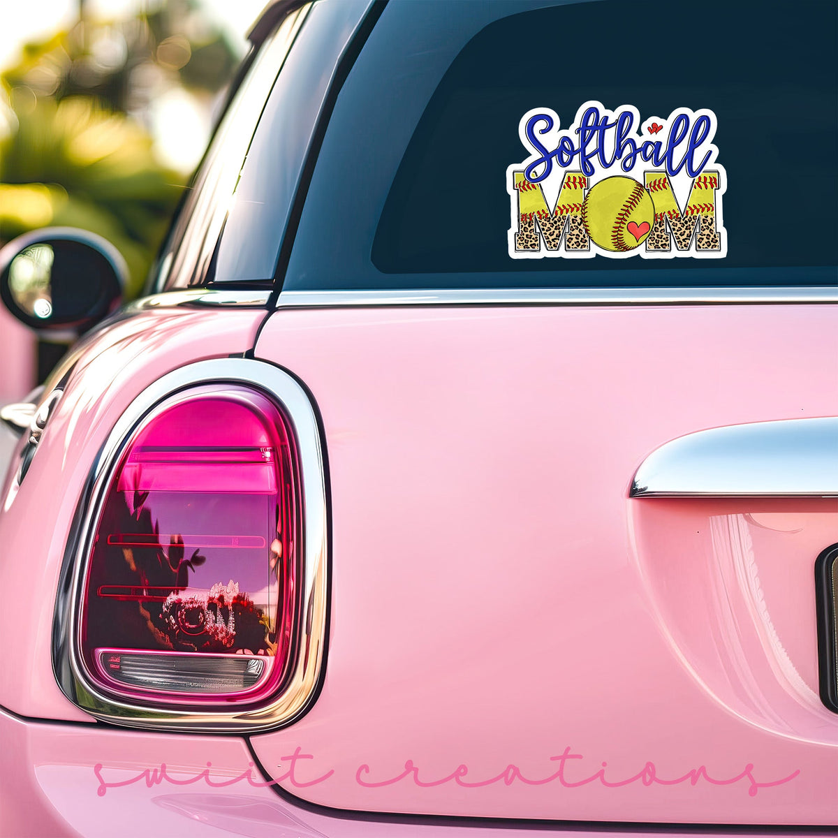 Softball Mom sticker on the back window of a pink car