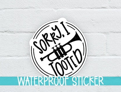Sorry I Tooted Trumpet sticker on a white brick background with a waterproof sticker banner