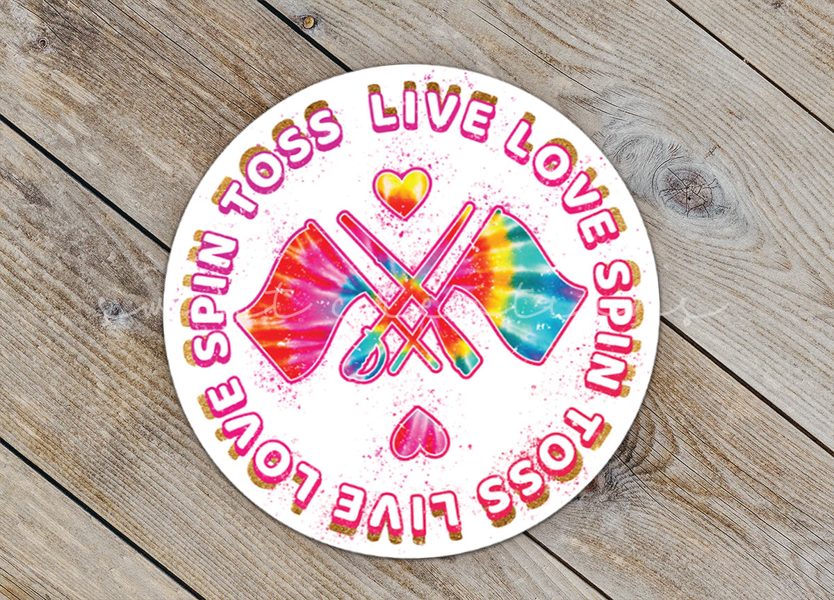 Close-up of the Spin Toss Live Love sticker on rustic wood