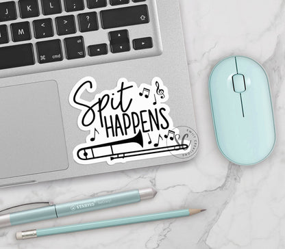Spit Happens vinyl sticker on a silver laptop next to a mint mouse and pens