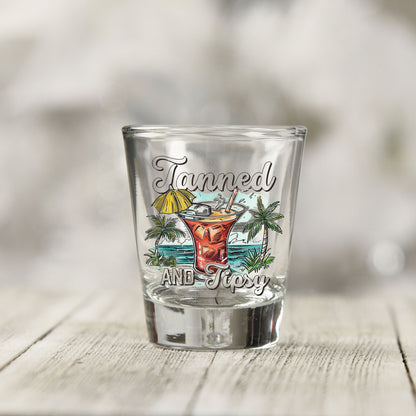 Close-up of the Tanned and Tipsy UV DTF transfer on a clear shot glass