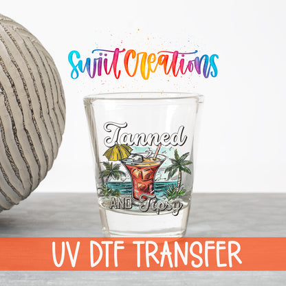 Tanned and Tipsy UV DTF transfer on a clear shot glass with the Swiit Creations logo and UV DTF Transfer banner