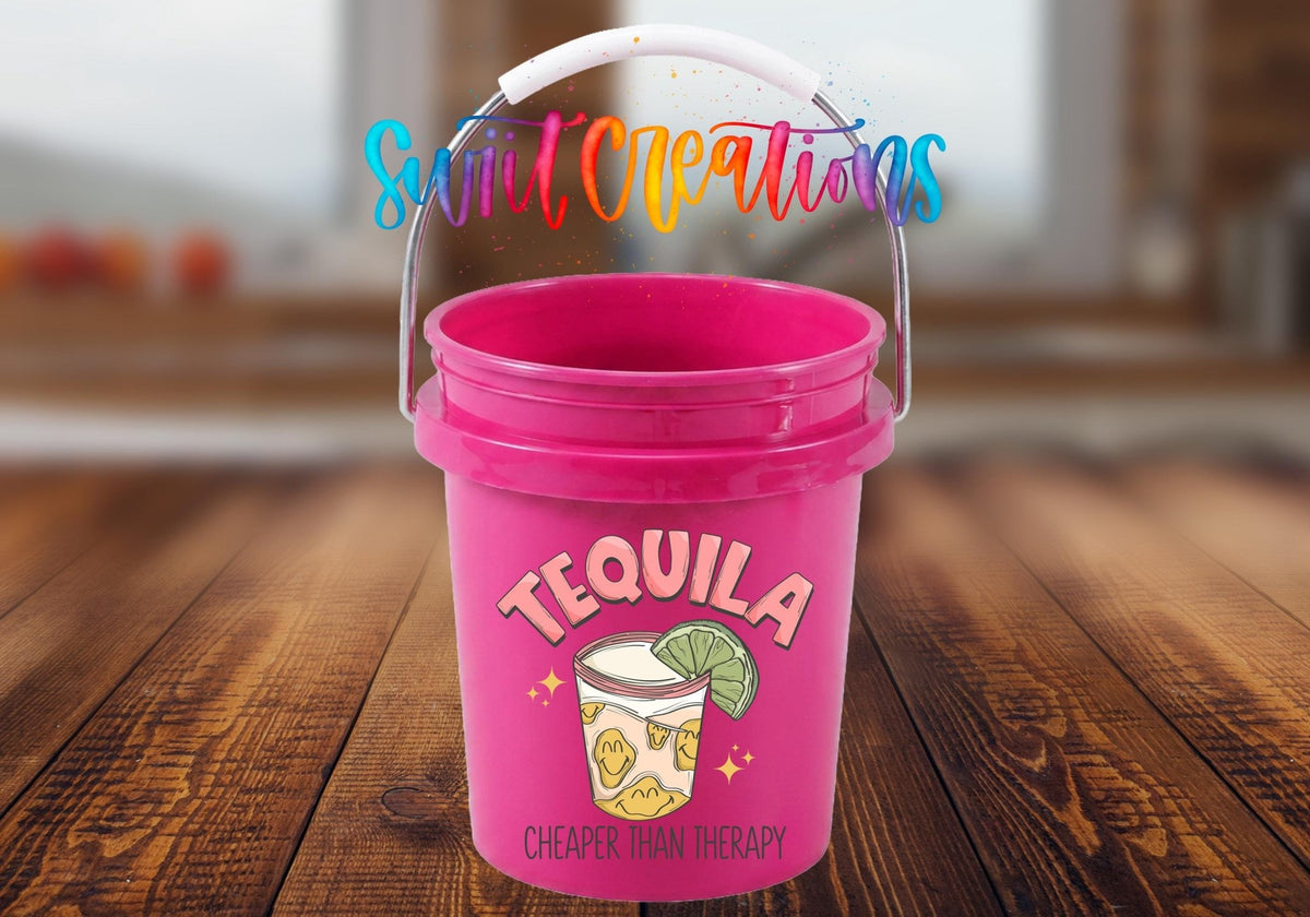 Tequila Cheaper Than Therapy UV DTF transfer on a pink mini bucket on a wood table