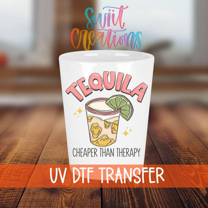 Tequila Cheaper Than Therapy shot glass transfer on a white shot glass on a wooden table