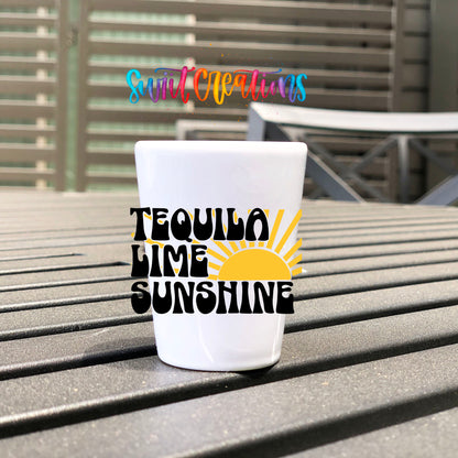 Tequila Lime Sunshine UV DTF transfer on a white shot glass on an outdoor patio table