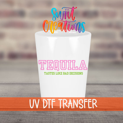 Tequila Tastes Like Bad Decisions UV DTF transfer on a white shot glass in front of a brick wall