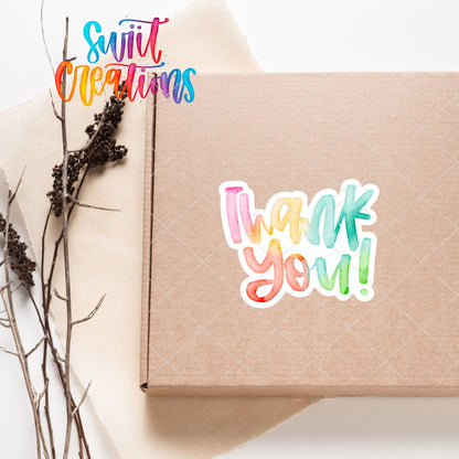 Watercolor Rainbow Thank You sticker on a kraft shipping box