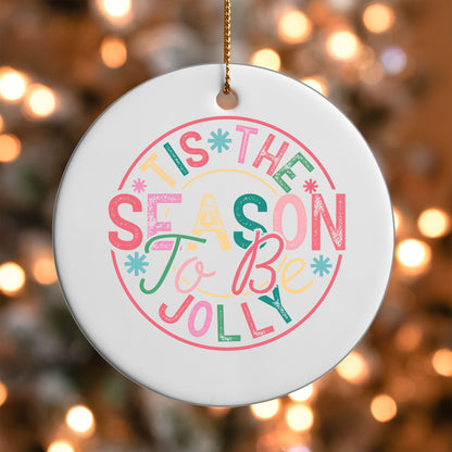 Tis the Season to Be Jolly ornament UV DTF transfer on a round white ornament with a bokeh light background