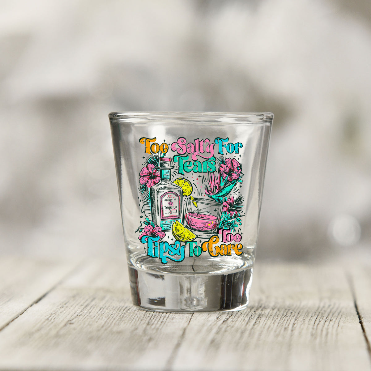 Close-up of the Too Salty For Tears Too Tipsy To Care UV DTF transfer on a clear shot glass