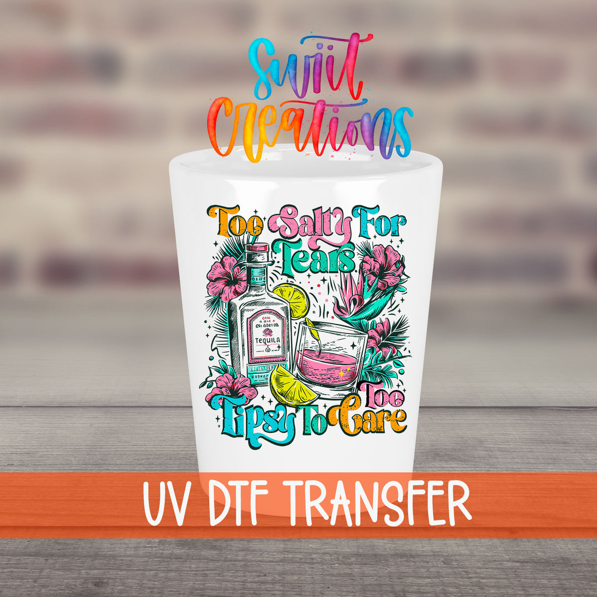 Too Salty For Tears Too Tipsy To Care UV DTF transfer on a white shot glass in front of a brick wall