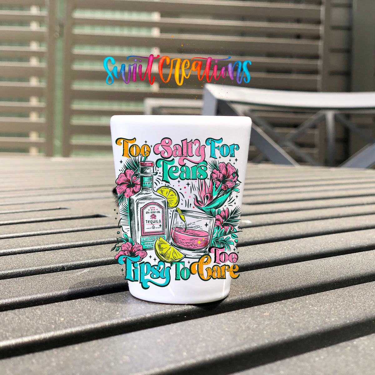 Too Salty For Tears Too Tipsy To Care UV DTF transfer on a white shot glass on an outdoor patio table