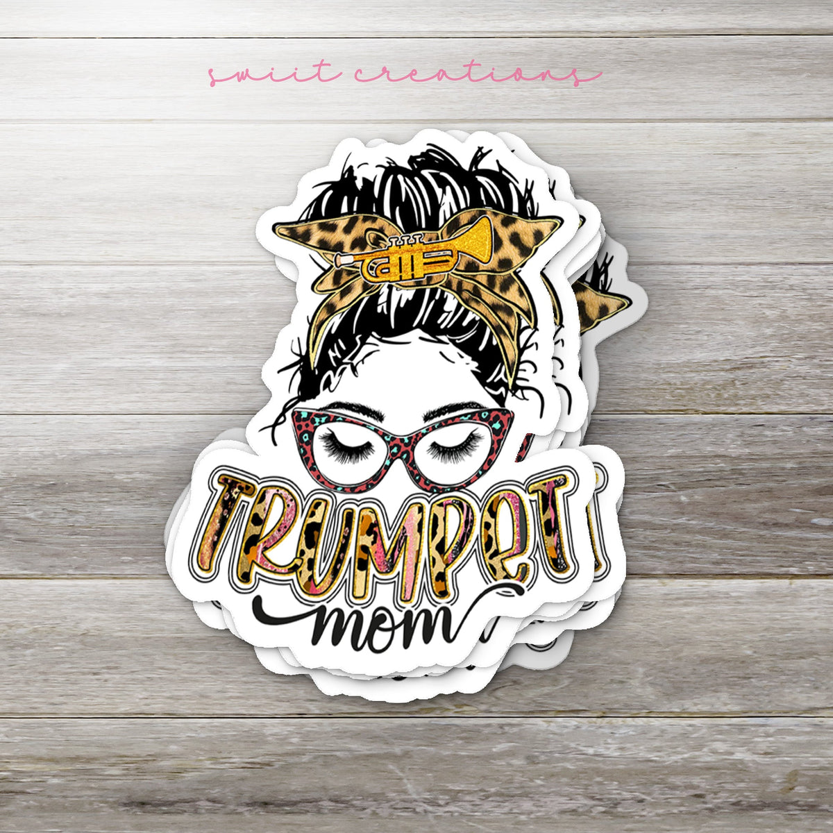 Stack of Trumpet Mom glossy stickers on a gray wood table