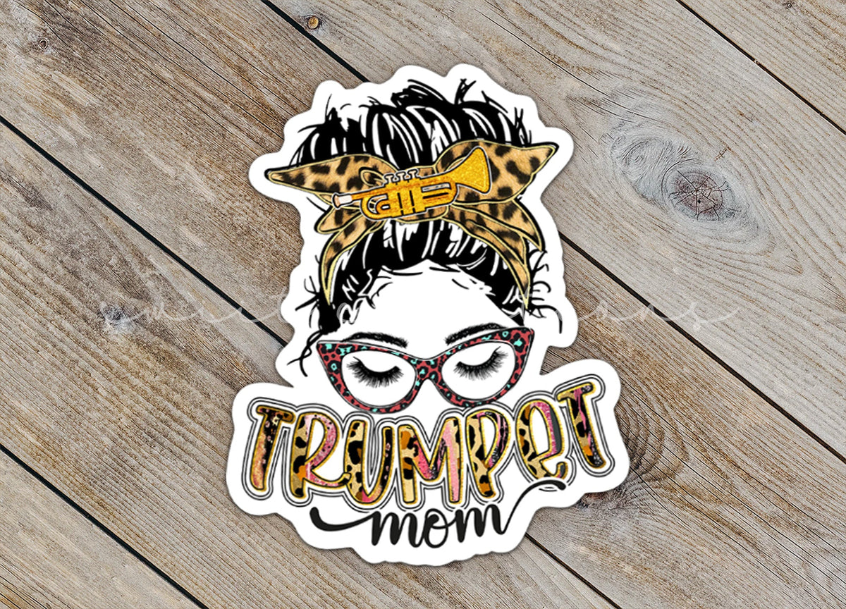 Close-up of the Trumpet Mom sticker on rustic wood