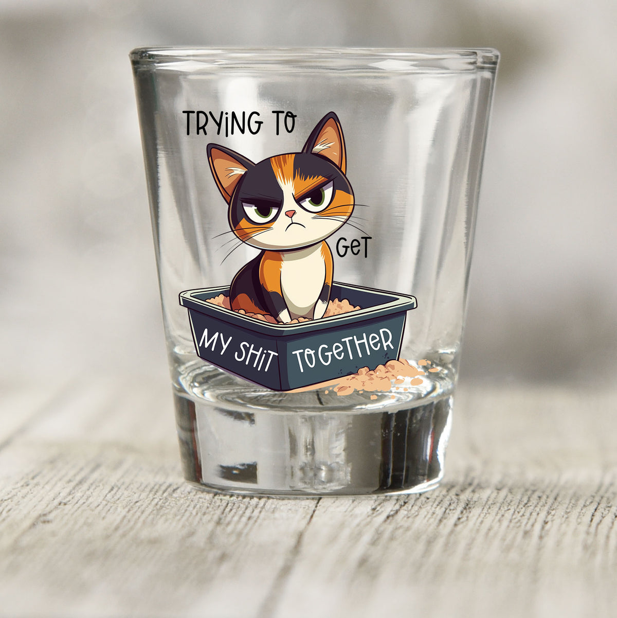 Trying to Get My Sh*t Together shot glass UV DTF transfer with grumpy calico cat in a litter box on a clear shot glass