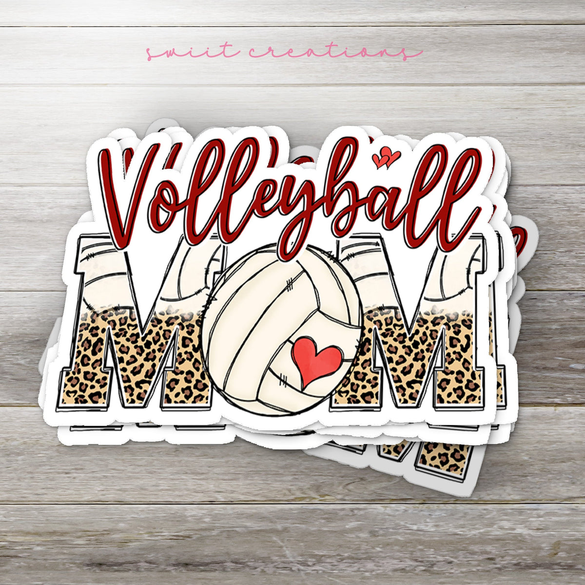Stack of Volleyball Mom glossy stickers on a gray wood table