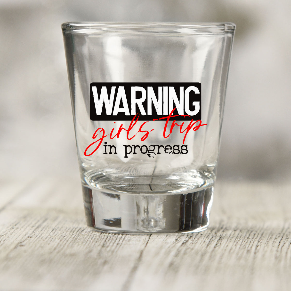 Warning Girls Trip in Progress shot glass UV DTF transfer with warning label style with red script on a clear shot glass