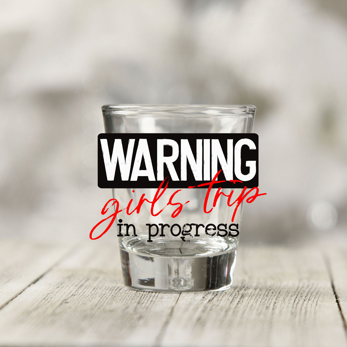 Close-up of the Warning Girls Trip in Progress UV DTF transfer on a clear shot glass