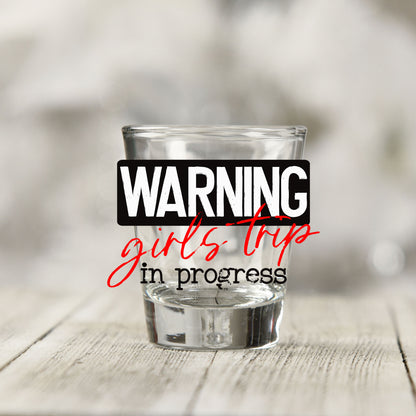 Close-up of the Warning Girls Trip in Progress UV DTF transfer on a clear shot glass