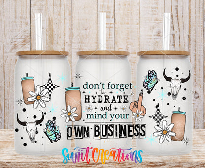 Don't Forget to Hydrate and Mind Your Own Business UV DTF wrap on three clear glass cans with bamboo lids