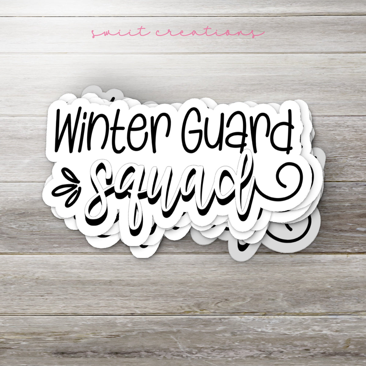 Stack of Winter Guard Squad glossy stickers on a gray wood table